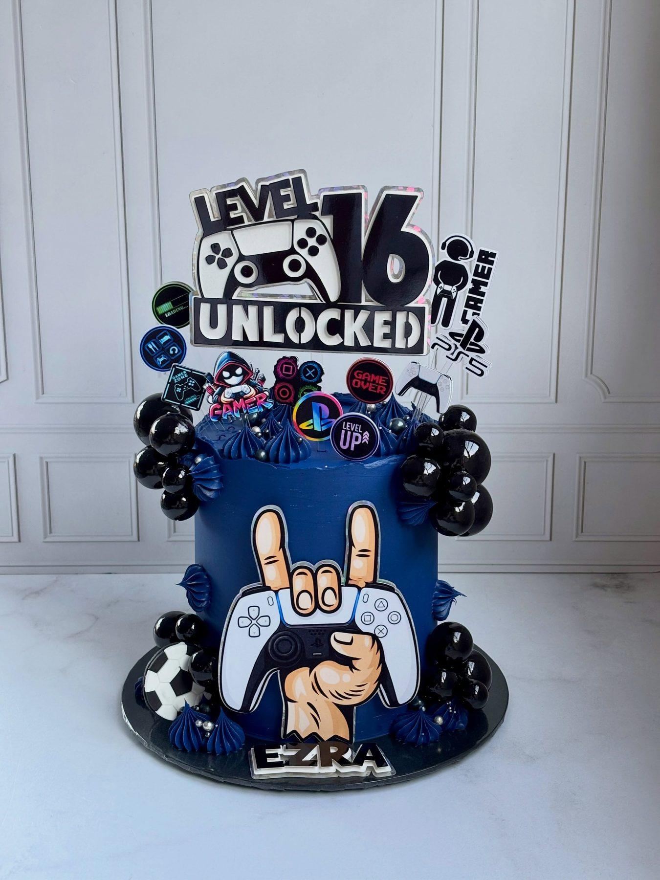 Gaming-themed birthday cake with a PS5 console and controller topper
