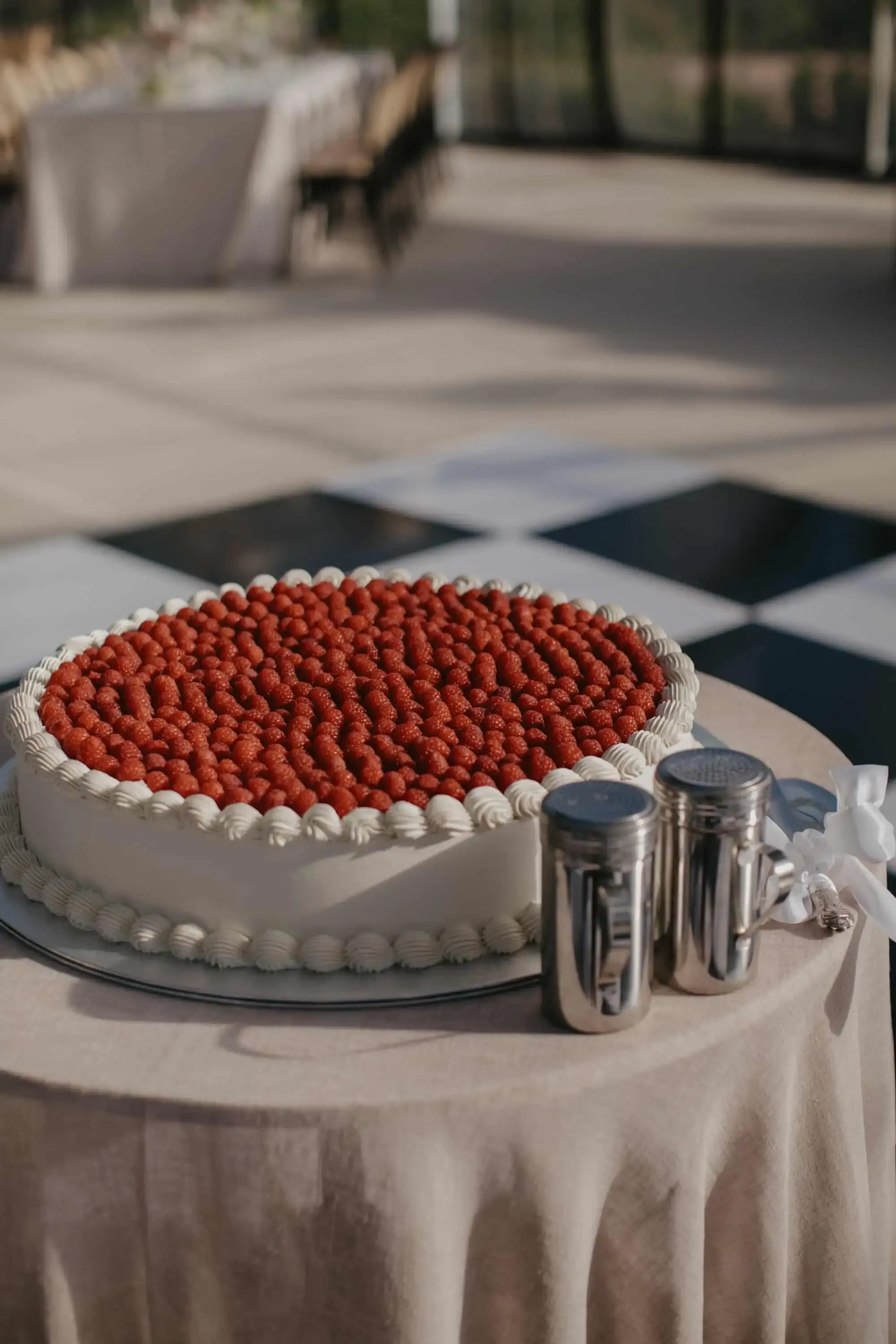 Round cake topped edge-to-edge with fresh strawberries, piped white border