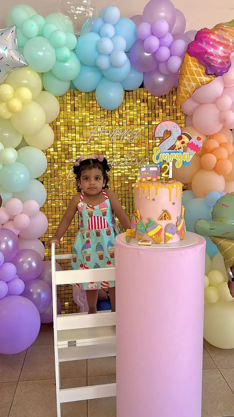 Two-tier drip cake with ice cream, pizza and sprinkle cookie toppers for a 2nd birthday